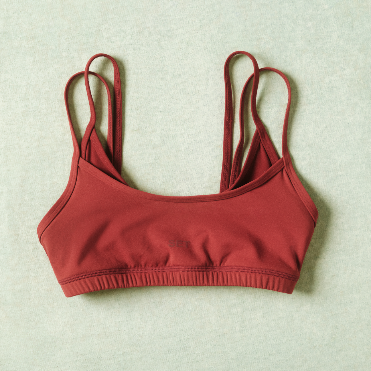 Red sports bra on a light green background