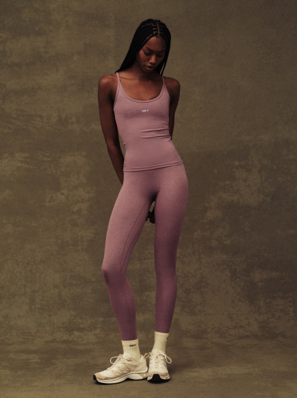 Woman wearing a red athletic outfit against a brown background