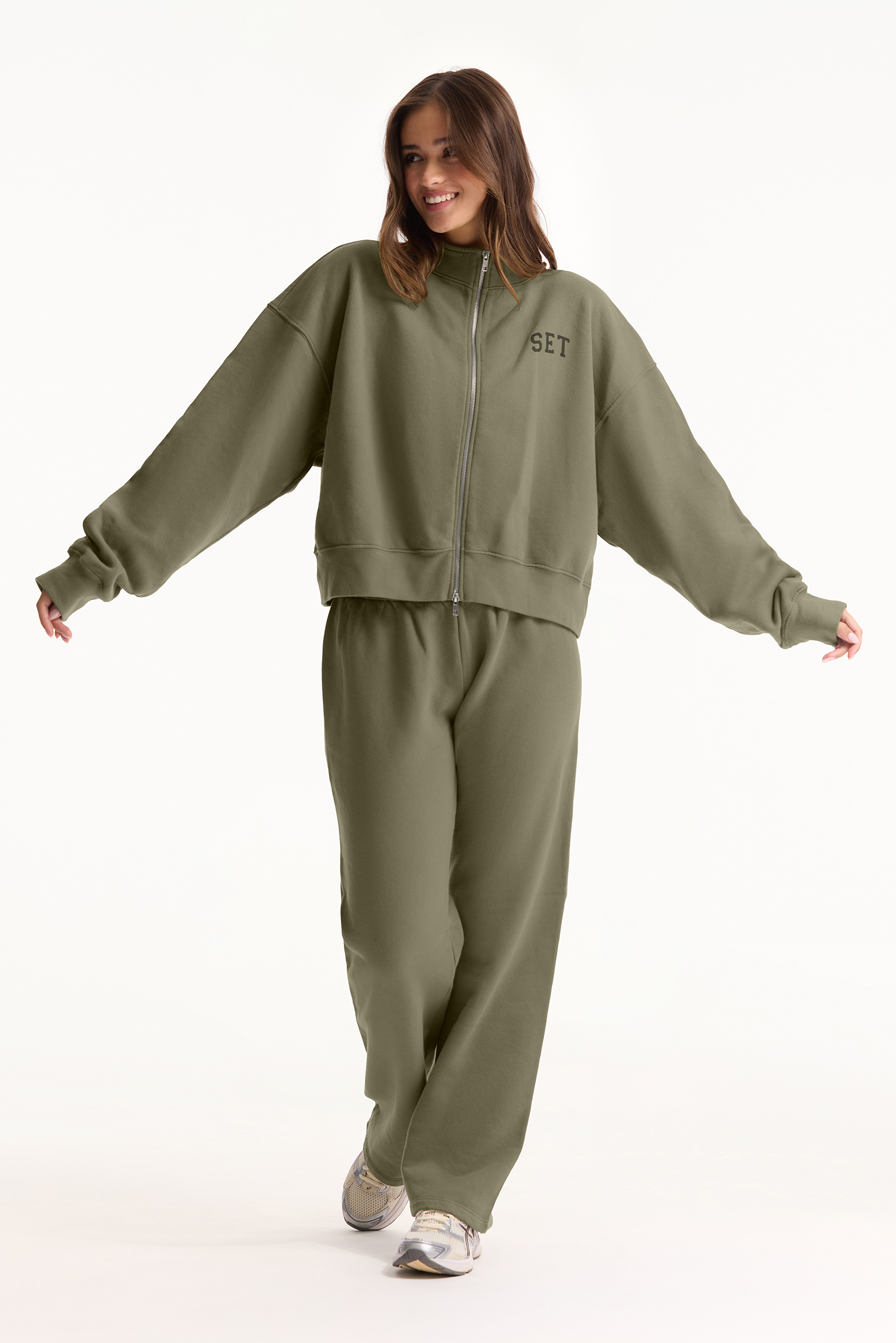 Person wearing a green tracksuit with 'SET' branding on a white background