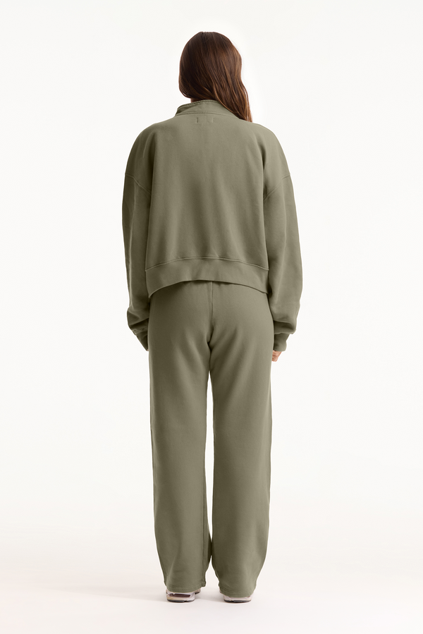 Person wearing a green tracksuit on a white background