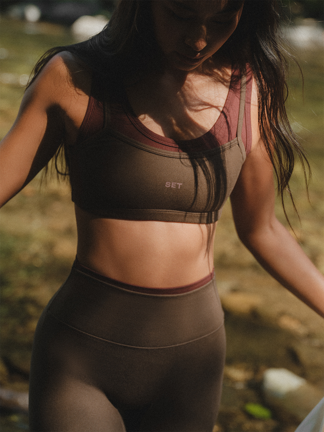 Person wearing a brown sports bra and leggings set outdoors.